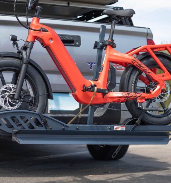 Two bikes mounted on a suspended hitch rack attached to a car