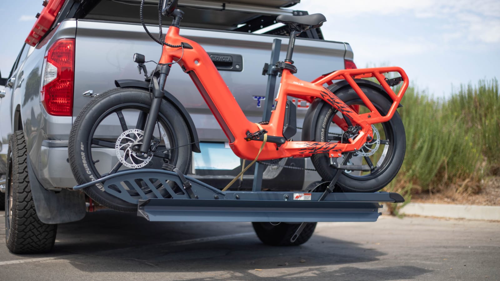 Two bikes mounted on a suspended hitch rack attached to a car