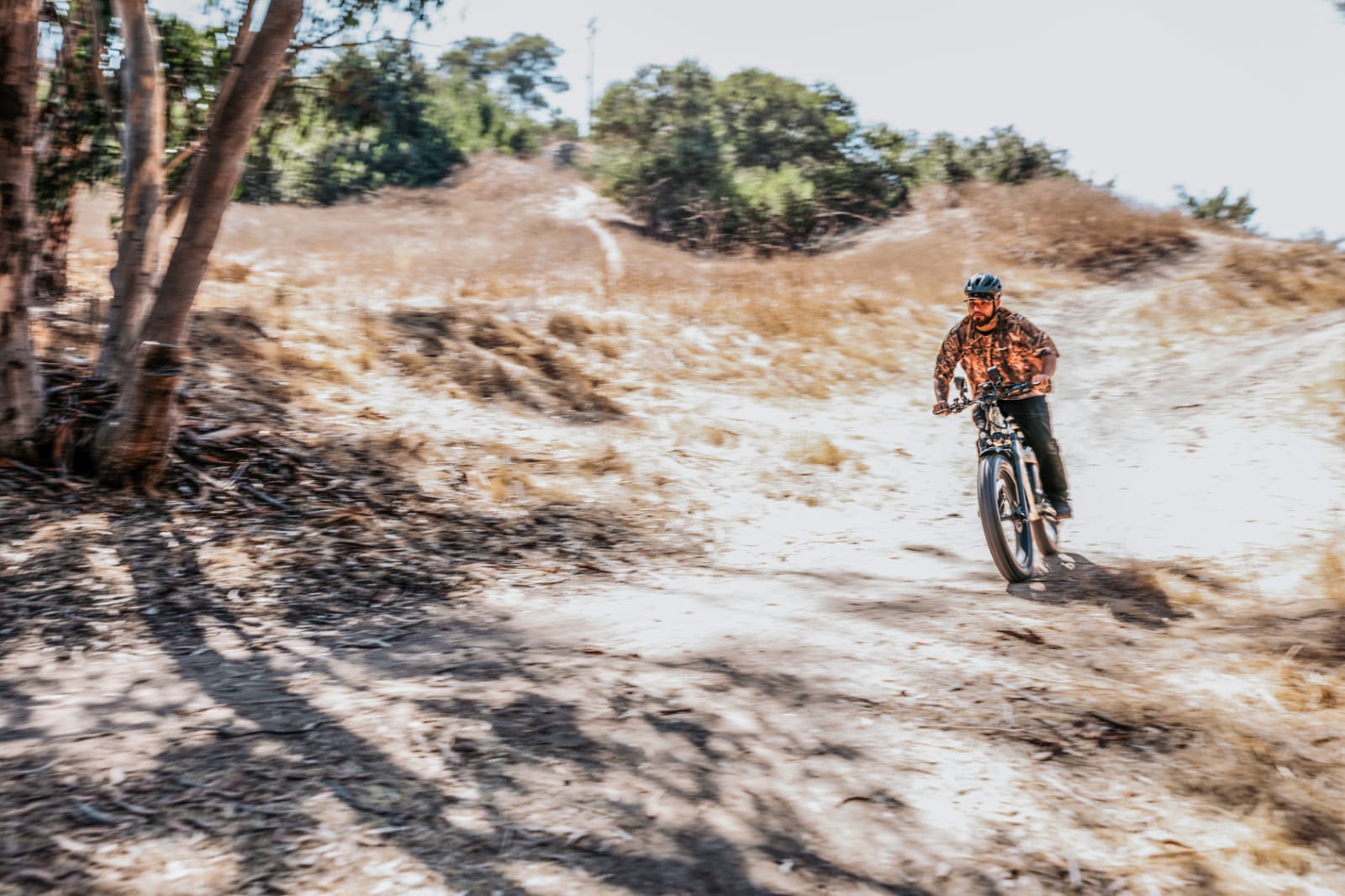 A fat tire electric bike equipped with an intelligent hybrid control system riding on a rugged trail.